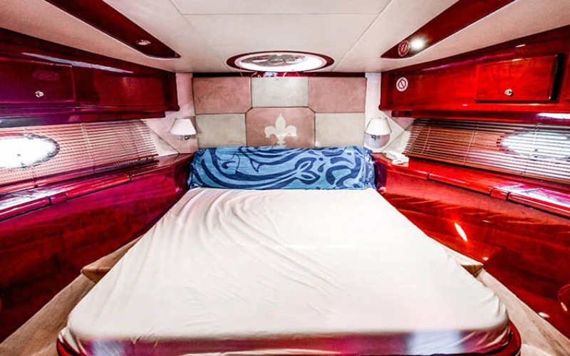 Luxurious master bedroom on Riva Yacht 50 with king-size bed, soft ambient lighting, full-height windows, and modern Italian décor