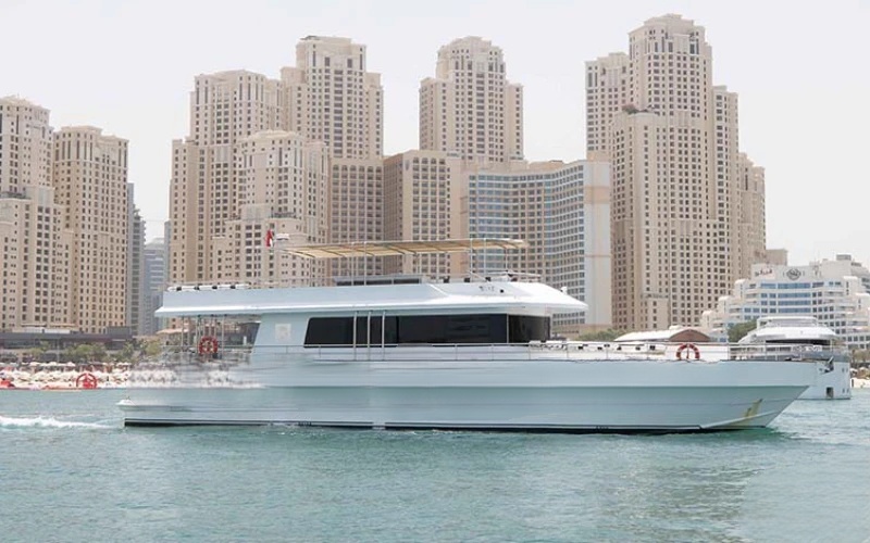 Pluto Yacht cruising near Dubai skyline – yacht rental Dubai by Mala Yachts