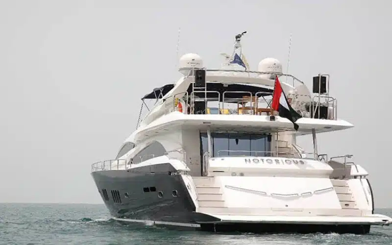 "Notorious Yacht cruising under Dubai skyline – signature yacht rental Dubai experience by Mala Yachts."