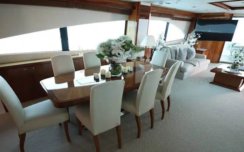 "Elegant dining setup aboard Notorious Yacht – fine dining with sea views on a Mala Yachts yacht rental Dubai."
