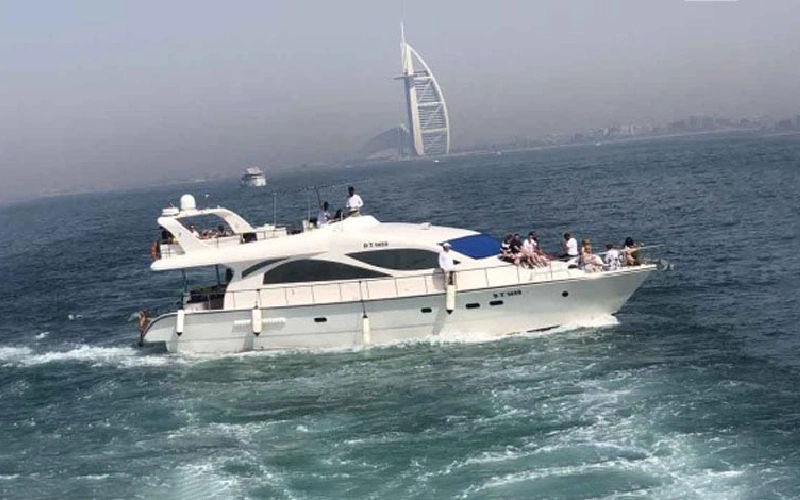 Side view of Mercury Yacht cruising along Dubai coastline – a majestic sight through Mala Yachts yacht rental in Dubai
