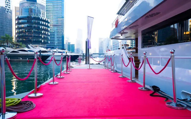 Red carpet entrance on Desert Rose Yacht offering a luxurious welcome experience – available through Mala Yachts yacht rental in Dubai