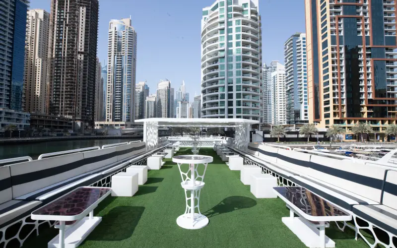 Outdoor seating on Desert Rose Yacht’s deck with views of Dubai skyline – part of Mala Yachts luxury yacht rental Dubai service