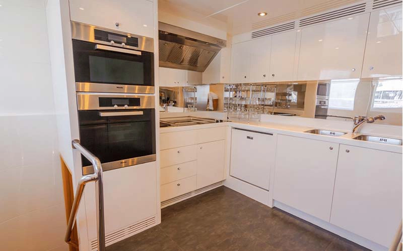 Fully-equipped kitchen on Majesty 121ft yacht featuring marble counters and modern appliances – included in Mala Yachts’ yacht rental Dubai services