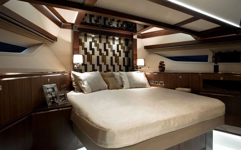 Cozy bedroom on Galeon Yacht featuring a queen-size bed, side lighting, and sea-view windows