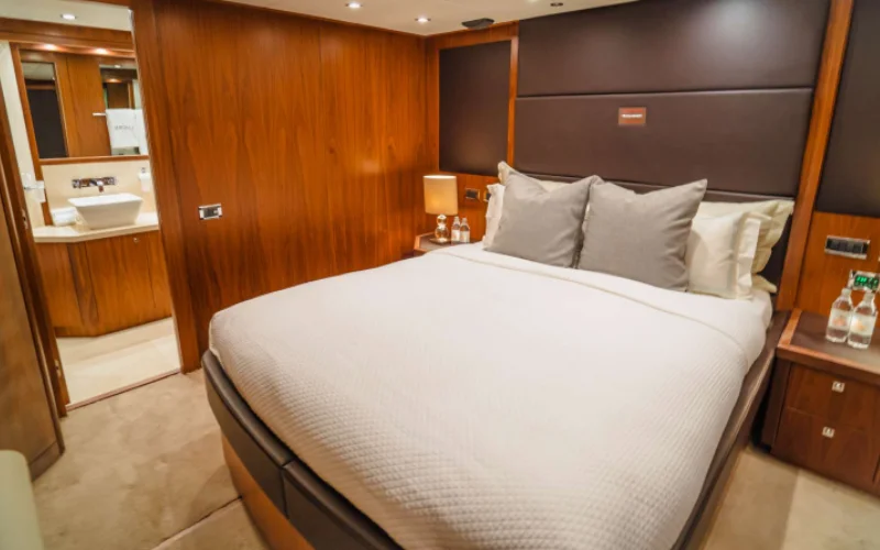 Luxury bedroom on Lucien 131 yacht with plush bedding and sea-facing windows – offered by Mala Yachts for premium yacht rental in Dubai
