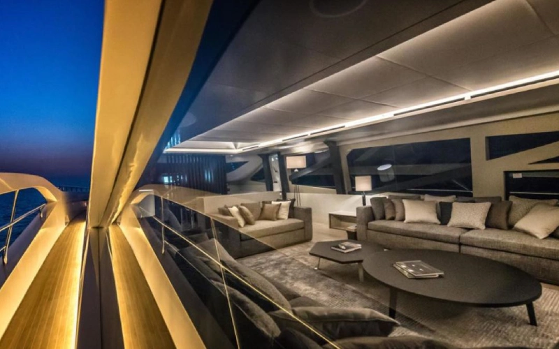 Indoor dining area on Dolce Vita Yacht featuring a polished wooden table, cushioned chairs, and large sea-view windows