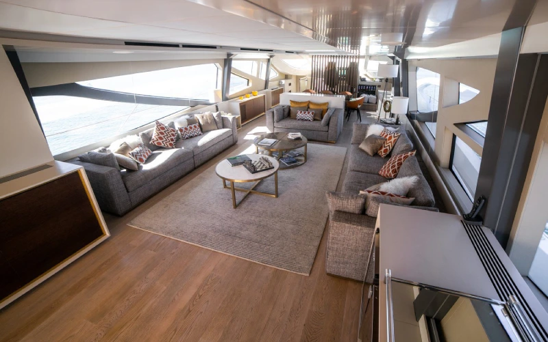 Elegant salon on Dolce Vita Yacht with plush sofas, wood finishes, and ambient lighting