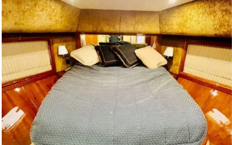 Spacious bedroom on Majesty 77ft Yacht with modern design, soft lighting, and ocean-view window