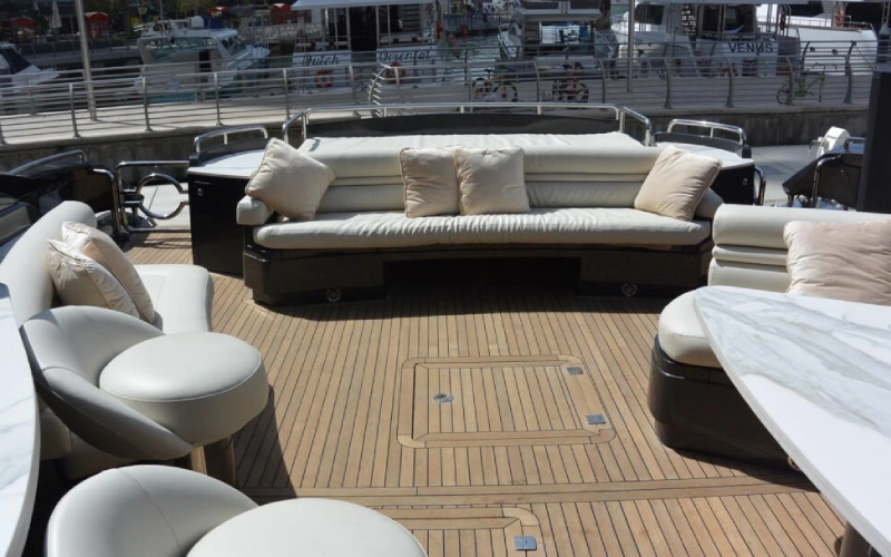 Upper deck sitting area on Black Beauty Yacht featuring luxury chairs and a shaded canopy