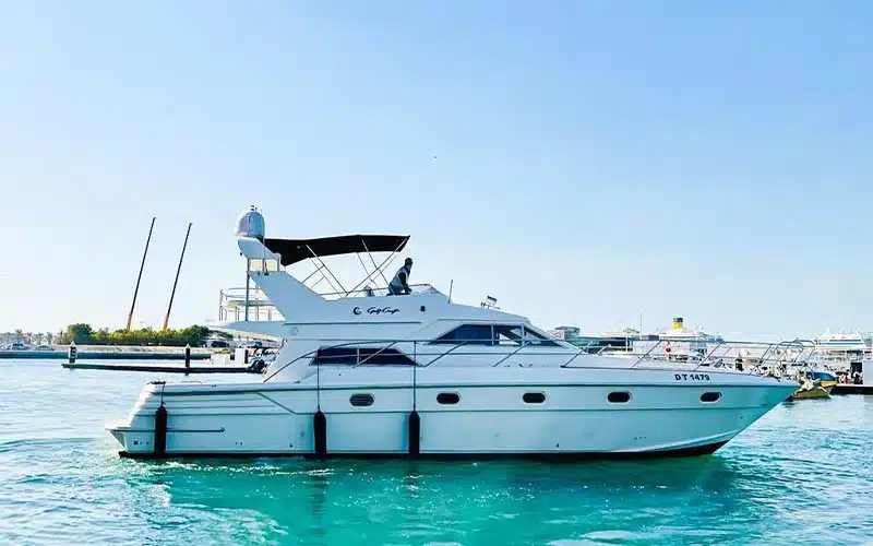 Aft profile of Integrity yacht docked at a marina showing its spacious deck, swim platform, and polished white hull under sunny skies