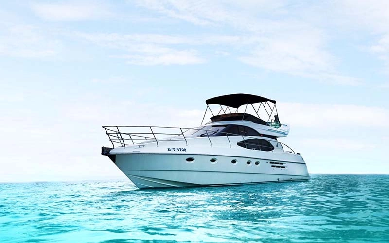 Major Yacht 52 ft cruising near the Dubai coastline with sleek white hull and sunlit deck seating