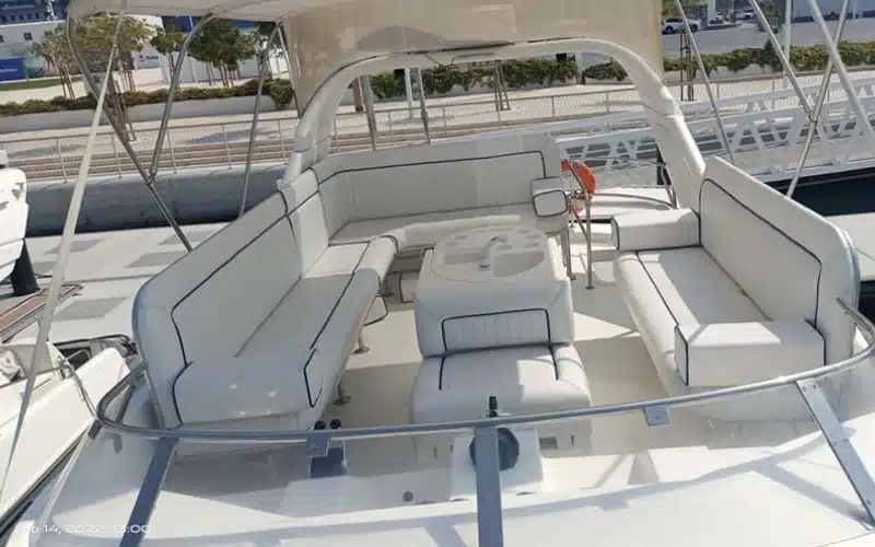 Cozy cabin inside Sun Rise Yacht featuring a double bed, wood paneling, and ambient sunrise lighting through porthole windows