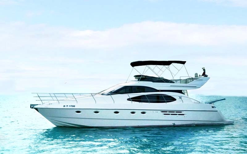 Side profile of Major Yacht anchored in clear water, showcasing spacious sunbathing and dining areas