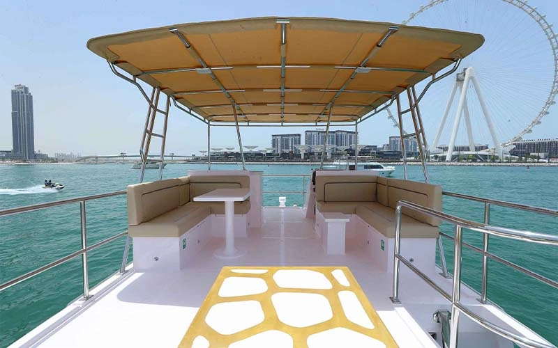 Main salon on Cooler Bird Yacht featuring large cream sofas, glossy wood cabinetry, and full-length side windows