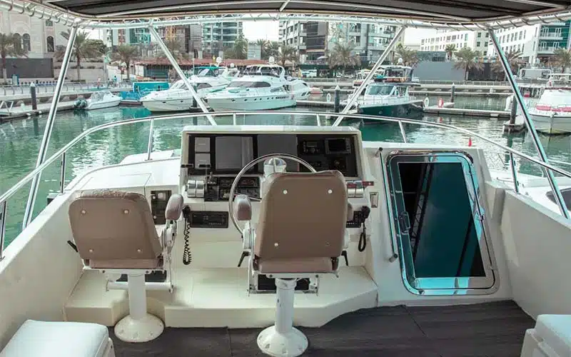 Captain’s helm aboard Gulf King Yacht featuring a state-of-the-art navigation dashboard, leather captain’s chair, and wide windshield offering clear ocean views