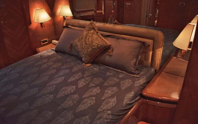 Spacious yacht cabin with wood accents, plush bedding, and ambient lighting aboard Speed Rock Yacht