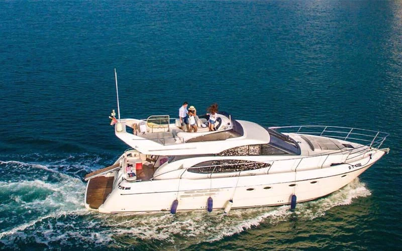 Major Yacht sailing along Dubai’s coastline with a sleek hull and guests relaxing on the bow
