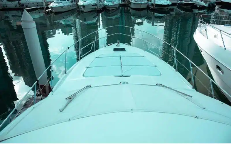 Upper deck of Wrong 2 Yacht featuring a stylish flybridge with cushioned seating, control helm, and 360-degree views of the sea—perfect for sunset cruising