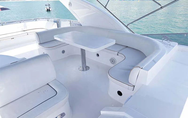 Dining area aboard Maze Yacht featuring wood dining table, upholstered chairs, and open-plan layout