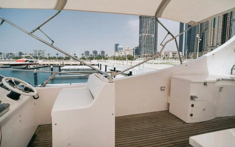 Captain’s helm station with navigation controls and panoramic windshield inside Mayas Yacht