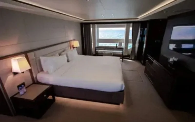 Elegant bedroom with king-sized bed and ocean-view windows on Legende Yacht