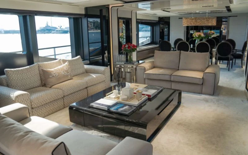 "Stylish lounge area inside Saffuriya yacht with panoramic windows – Mala Yachts premium yacht rental in Dubai"
