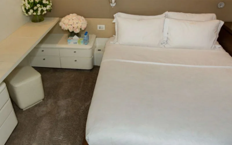 VIP cabin with large bed, elegant lighting, and ocean-view windows in Khalili Yacht