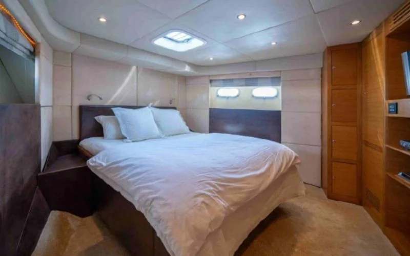 Luxurious bedroom suite on the Kronos yacht with elegant décor and cozy atmosphere – enjoy overnight comfort with Mala Yachts’ yacht rental in Dubai.