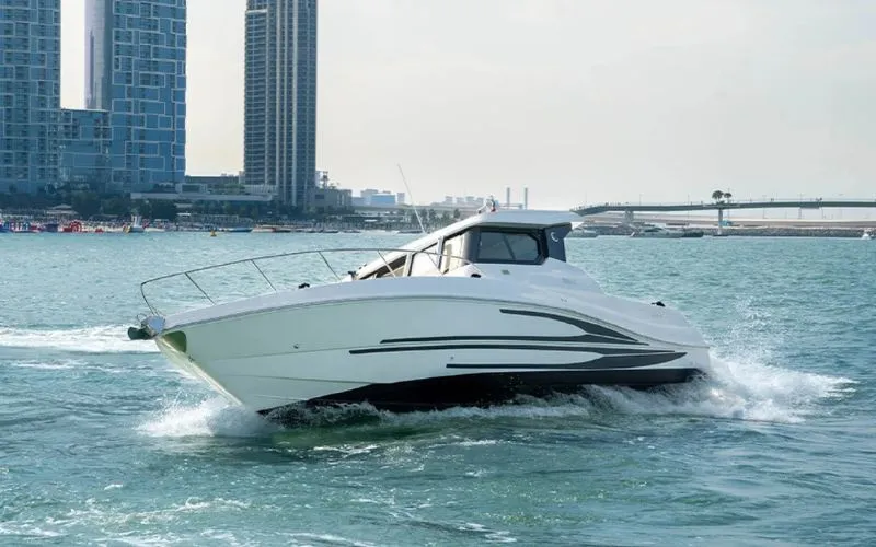 Storm 36ft yacht vibing along the Dubai skyline under clear skies – experience unforgettable yacht rental in Dubai with Mala Yachts.