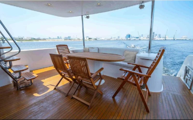 Cozy outdoor seating area on the Kronos yacht with panoramic views of Dubai – Mala Yachts provides relaxing open-air yacht rental in Dubai experiences.