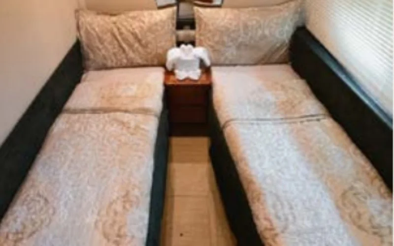 Spacious double bedroom aboard the Etosha yacht featuring twin beds and modern design – enjoy comfortable and stylish yacht rental in Dubai with Mala Yachts.