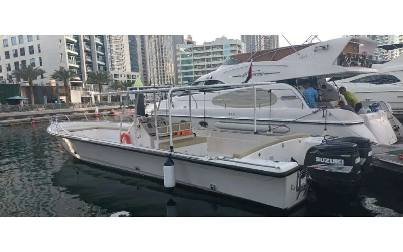 A modern, well-equipped boat from the Mala Yachts fleet, viewed from the stern while moored in Dubai Marina, available for private yacht rental.