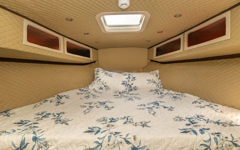 Cozy bedroom cabin aboard the Riverside yacht featuring elegant finishes – enjoy luxurious overnight yacht rental in Dubai with Mala Yachts.