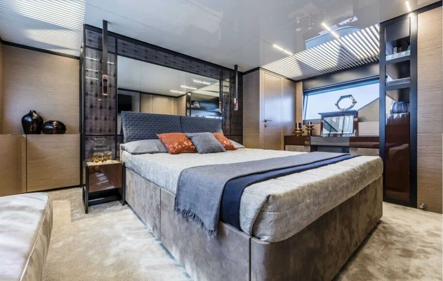 Master bedroom of Ferretti 78 featuring modern lighting and premium bedding – unwind in refined luxury with Mala Yachts’ yacht rental in Dubai.