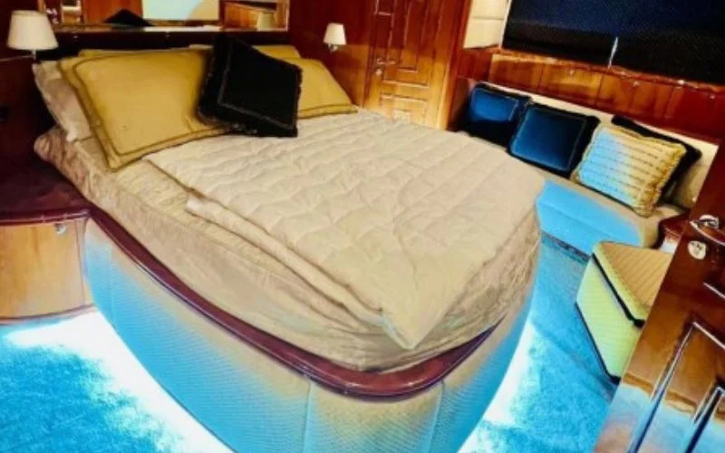 Luxurious master bedroom aboard Majesty 70ft yacht featuring large windows and soft lighting – relax in comfort with Mala Yachts’ yacht rental in Dubai.