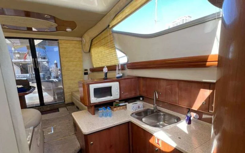 Modern kitchen (galley) aboard the Cranchi yacht with sleek cabinetry and stainless-steel appliances – Mala Yachts offers full-service yacht rental in Dubai with onboard culinary convenience.