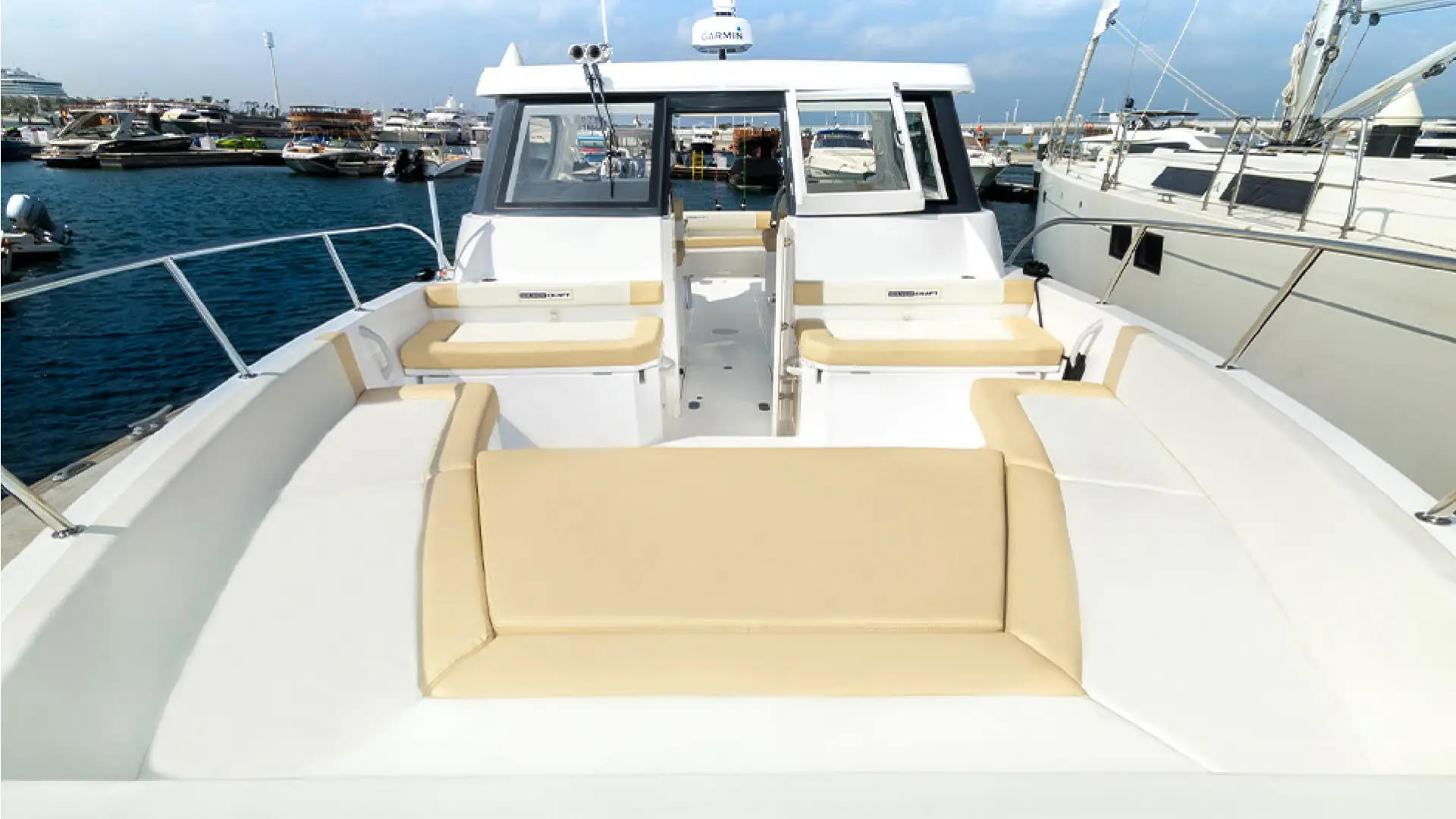 Spacious and inviting forward deck of the 36ft yacht Dubai by Malayachts.ae, featuring ample beige cushioned seating.