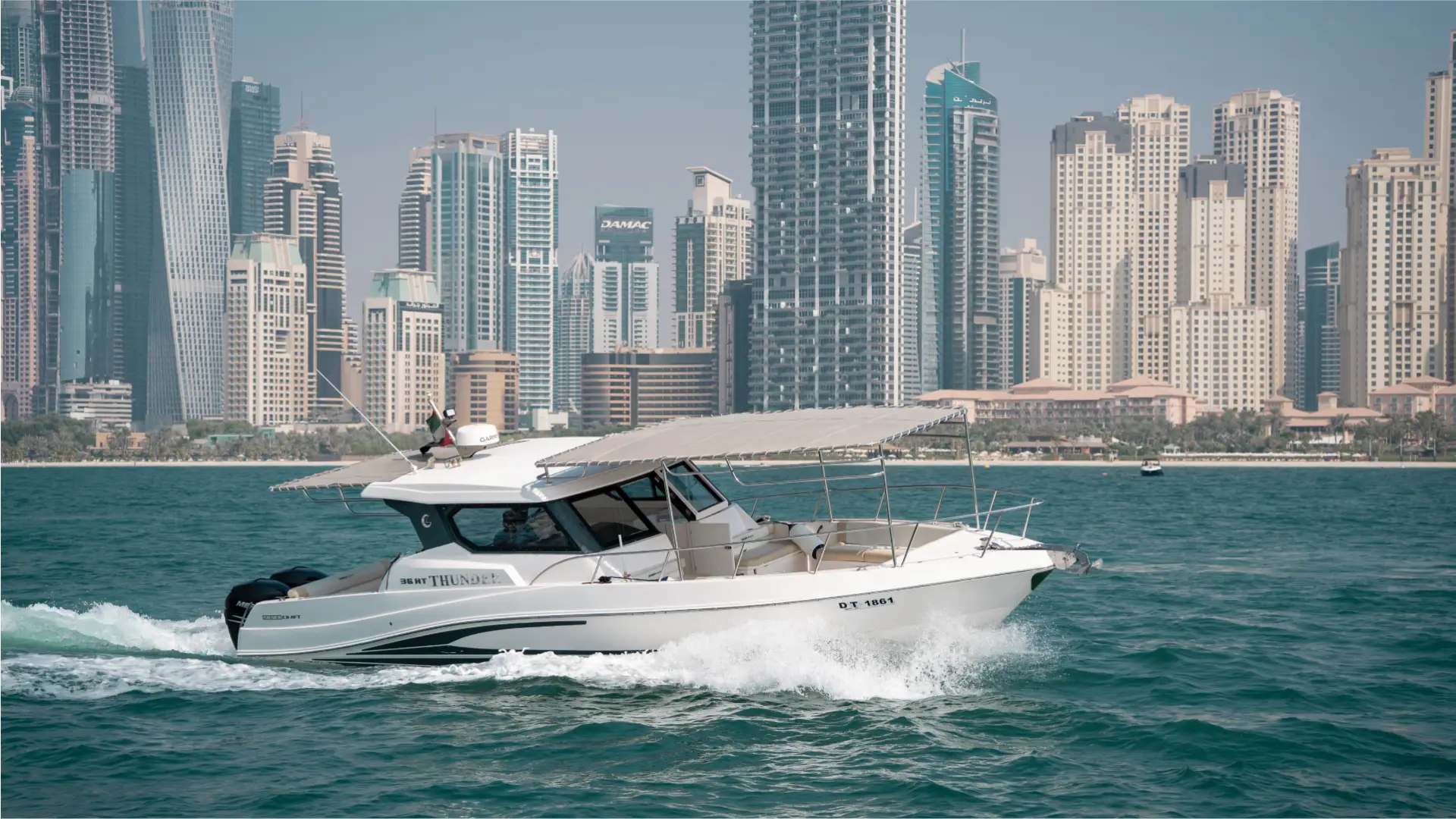 Enjoying a dynamic ride on the 36ft yacht Dubai, offered by Malayachts.ae, against the iconic landmarks of Dubai.