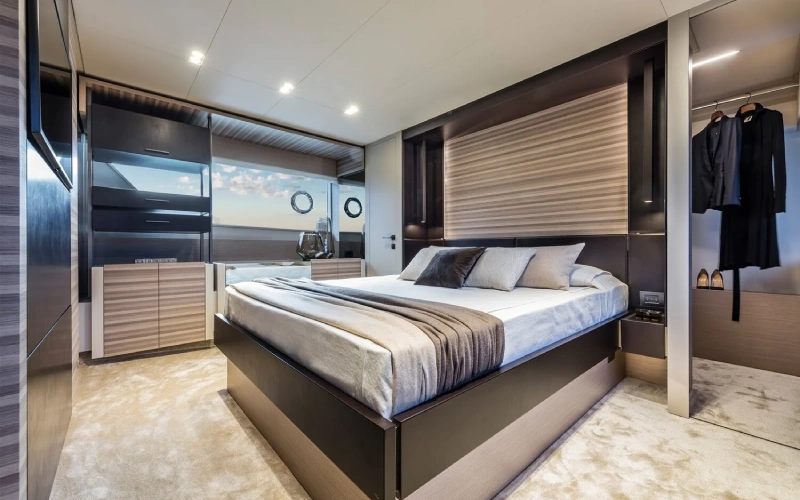 Spacious and elegantly designed bedroom on Ferretti 67 yacht featuring plush bedding and ambient lighting – enjoy premium comfort with Mala Yachts’ yacht rental in Dubai.
