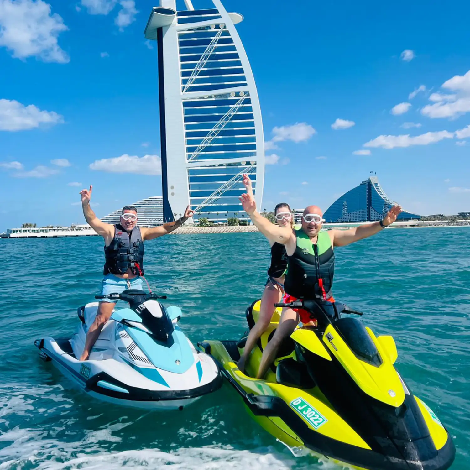 Guest jumping waves on a jet ski beside the yacht